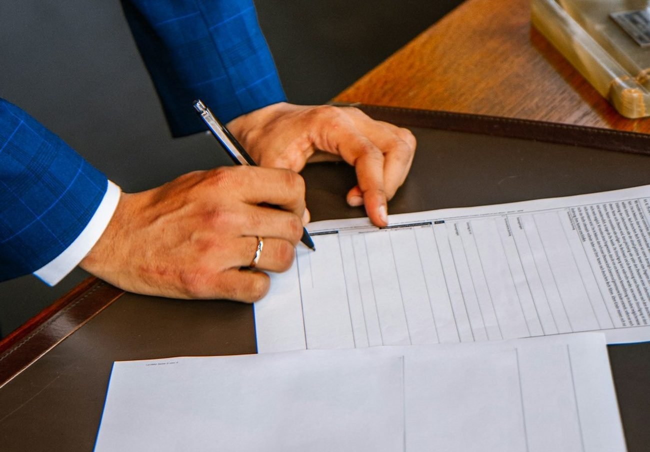 Client filling in tax documents with a pen